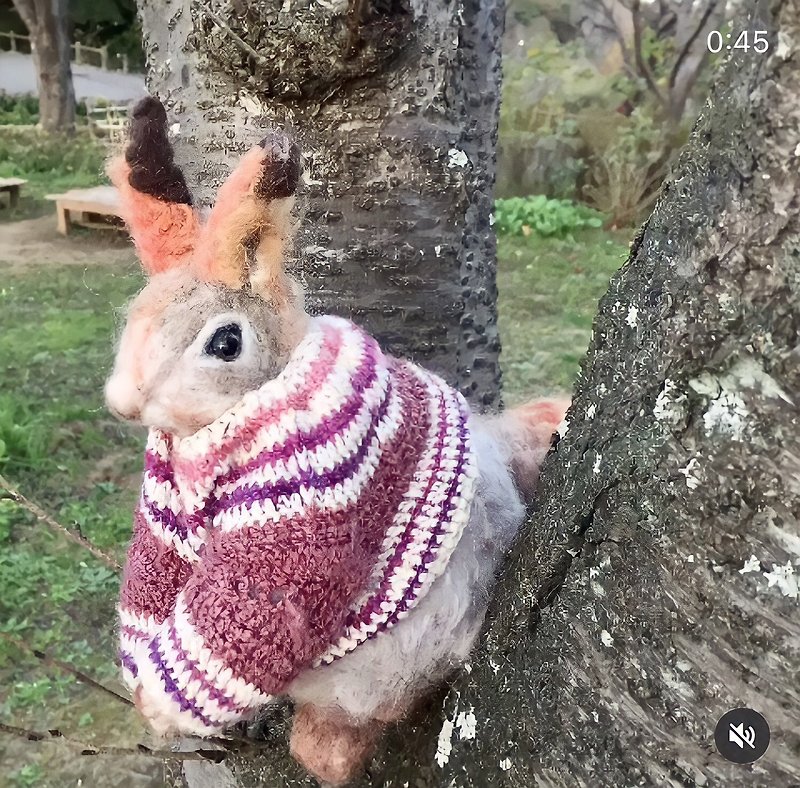 Eurasian red  squirrel in a pink Nordic sweater made with wool felt